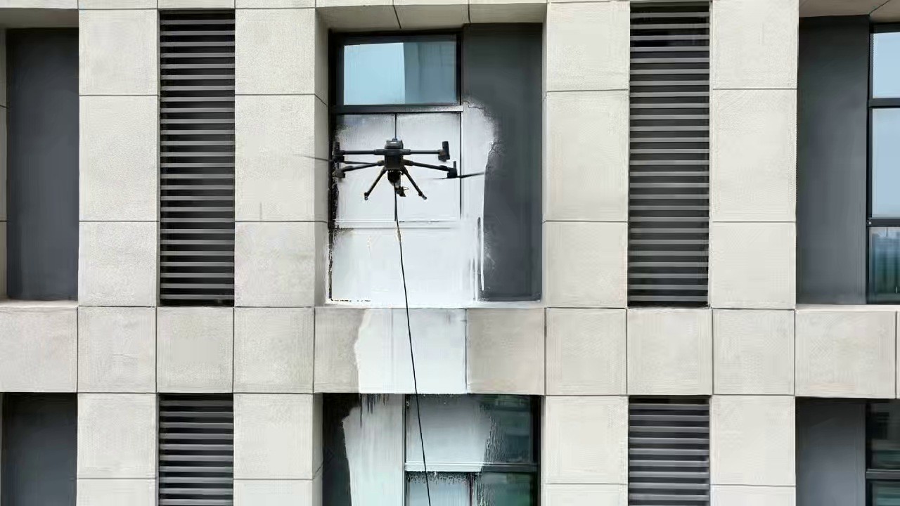 Dron DJI Matrice 400 s mycím ramenem nanáší pěnu na kamennou fasádu